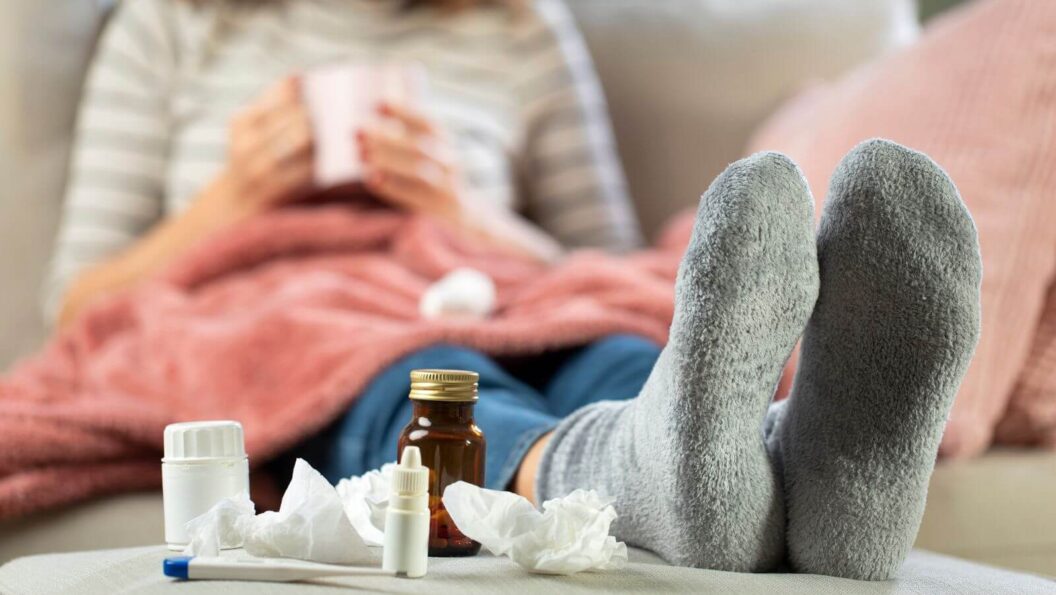 Frau krank auf dem Sofa mit Medikamenten