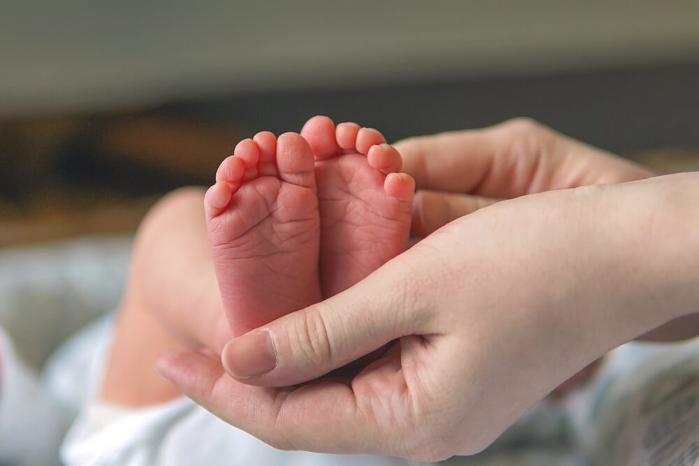 Fersentest: Babyfüße, die von einer Hand gehalten werden