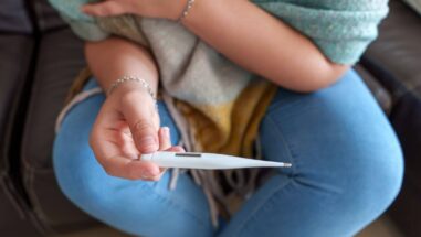 Zum Artikel: Frau mit Fieberthermometer