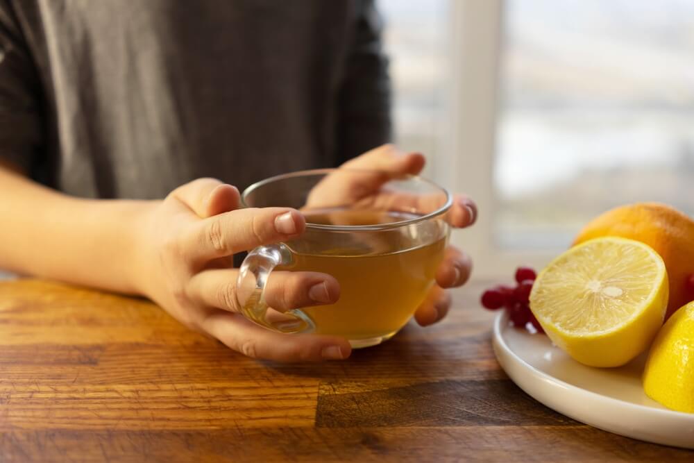 Kind hält Tee mit Zitrone