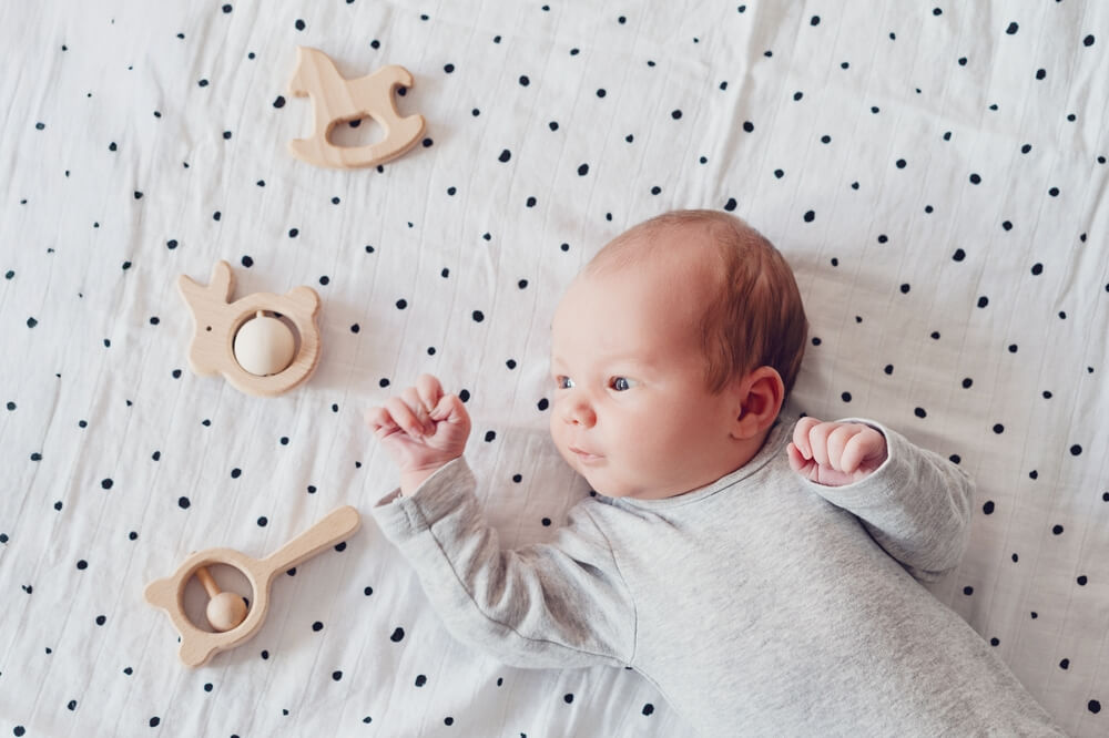 Baby auf der Decke mit Spielzeug