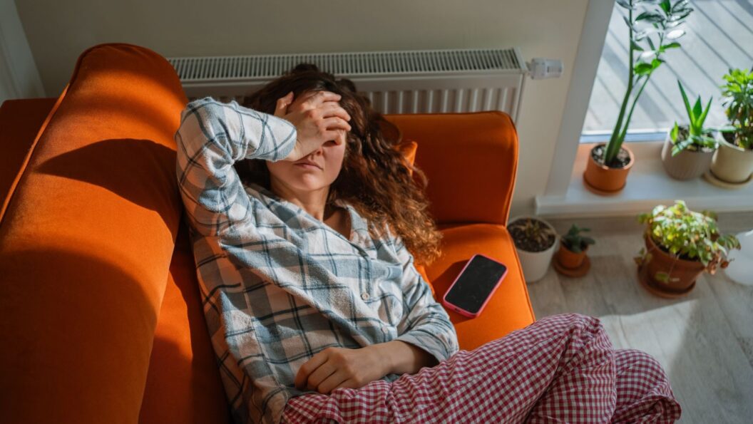 Silent Inflammation: Frau liegt erschöpft auf der Couch