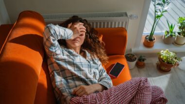 Zum Artikel: Silent Inflammation: Frau liegt erschöpft auf der Couch