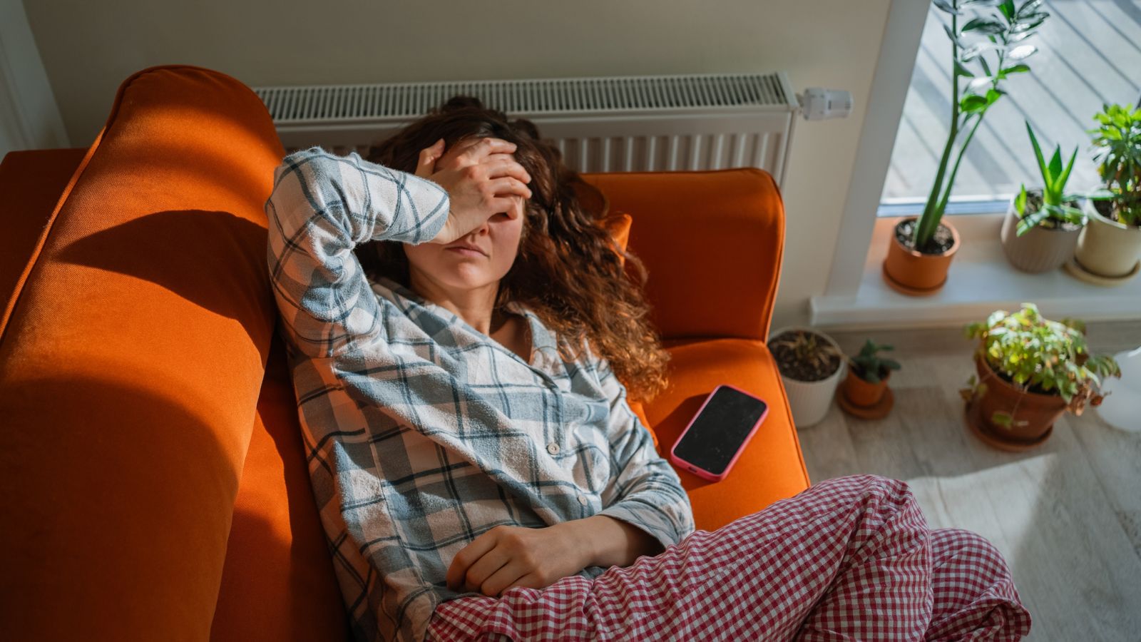 Silent Inflammation: Frau liegt erschöpft auf der Couch