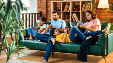 Zum Artikel: Smartphone-Sucht: Famile auf der Couch; jeder mit seinem Smartphone