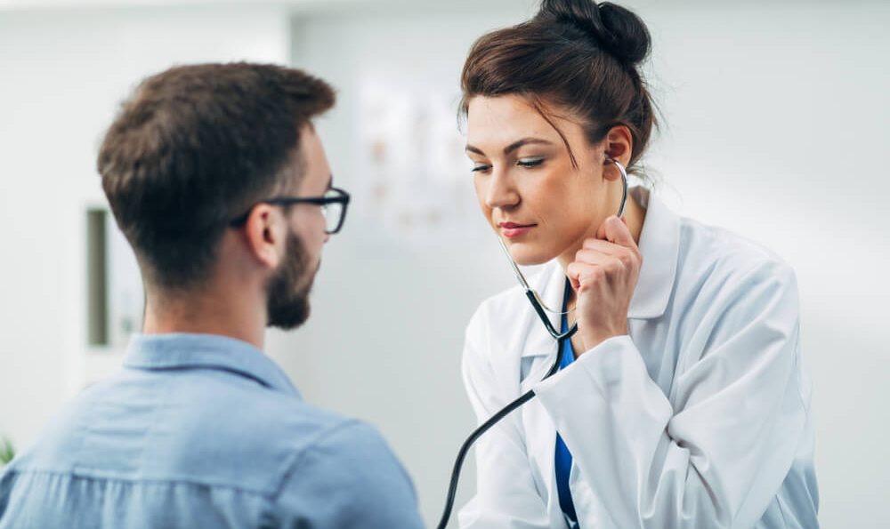 Ärztin untersucht Patient mit dem Stethoskop im Rahmen einer Gesundenuntersuchung