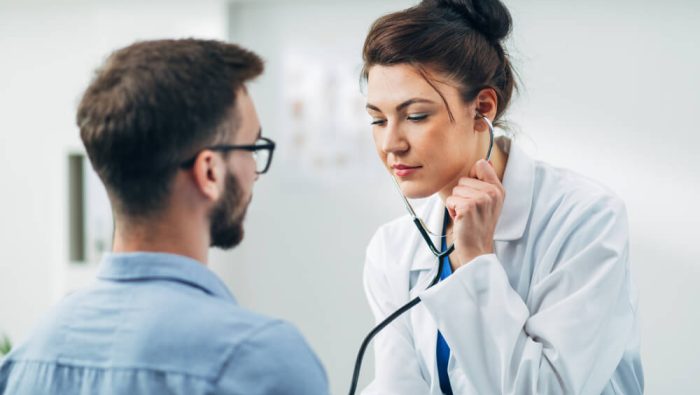 Ärztin untersucht Patient mit dem Stethoskop im Rahmen einer Gesundenuntersuchung