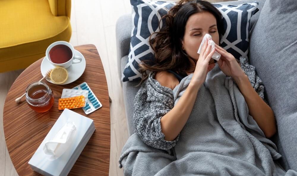 Frau liegt krank im Bett