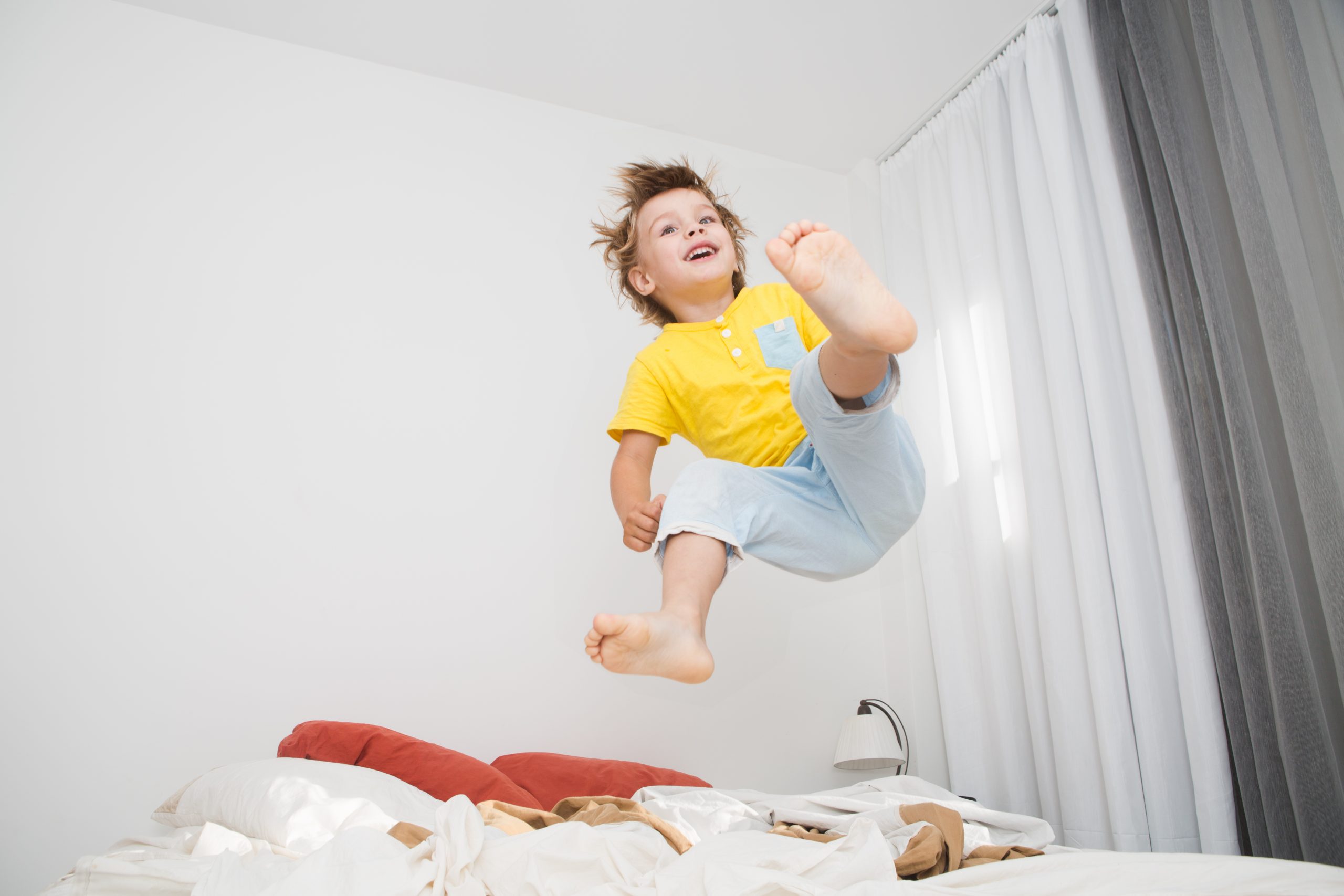 Kind hüpft im Bett